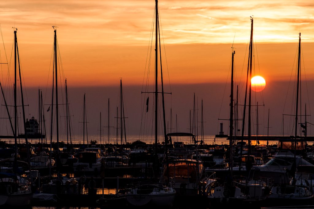 A picturesque sunset over a marina filled with sailboats