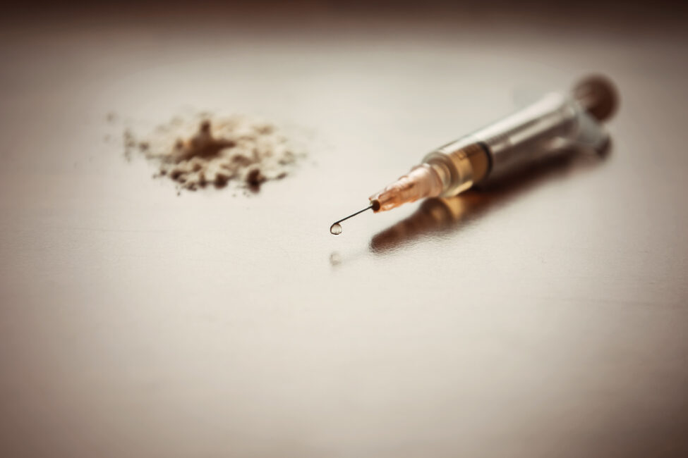 An injection needle and powder drugs on a table